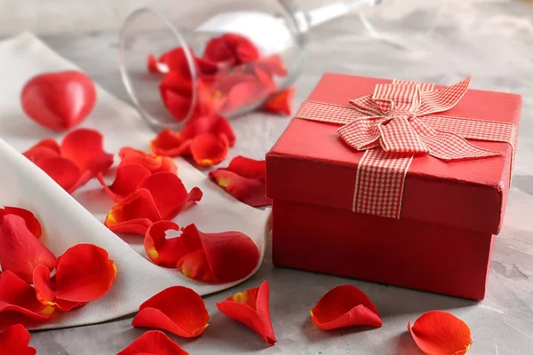 Gift box, płatki i wino szkło — Zdjęcie stockowe
