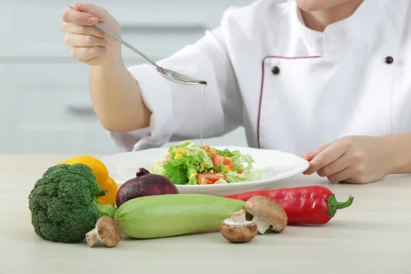 Chef derramando óleo na salada — Fotografia de Stock