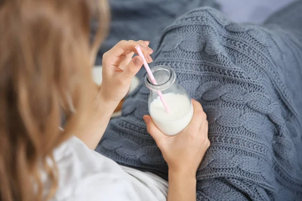 Mladá žena s lahví mléka — Stock fotografie