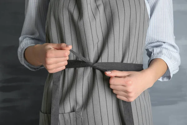 Mulher amarrando seu avental — Fotografia de Stock