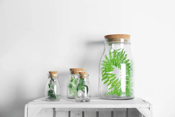 Glass bottles with leaves — Stock Photo, Image