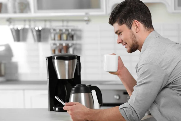 man drinking coffee at kitchen