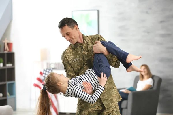 Soldado em camuflagem brincando com sua filha em casa — Fotografia de Stock