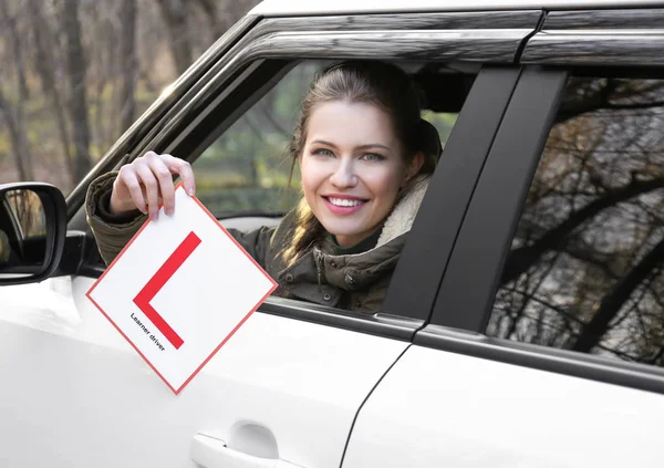 Жінка тримає знак водія учня — стокове фото