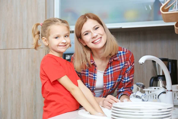 Niña y madre lavar los platos —  Fotos de Stock