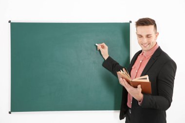Blackboard yanında genç erkek öğretmen 