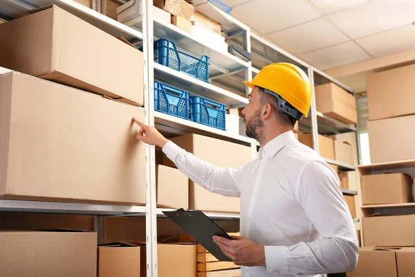 Businessman with clipboard in warehouse — Stock Photo, Image