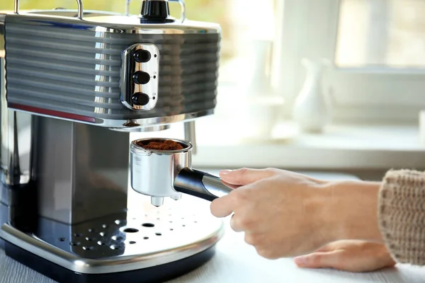 Женщина делает эспрессо в кофеварке — стоковое фото