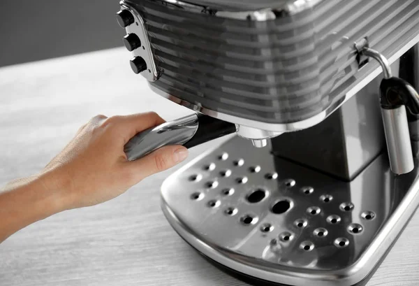 Женщина делает эспрессо в кофеварке — стоковое фото