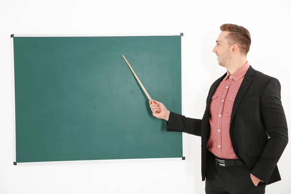 Jonge mannelijke leraar naast blackboard — Stockfoto