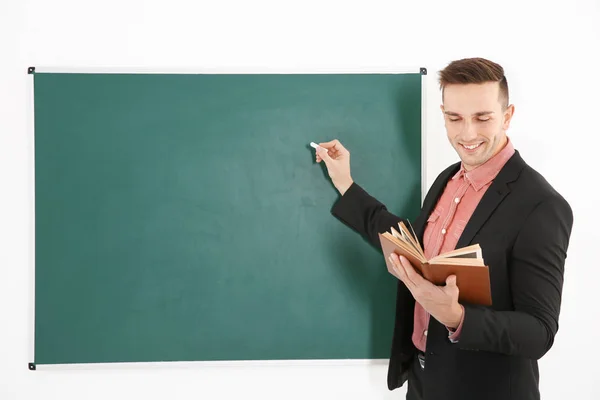 Young male teacher beside blackboard — Stock Photo, Image