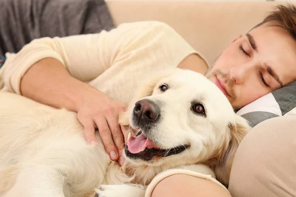 Homem com cão dormindo no sofá — Fotografia de Stock