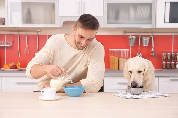 Människa och hund njuter av frukost — Stockfoto