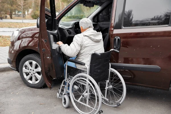 Homme en fauteuil roulant à côté de la voiture — Photo