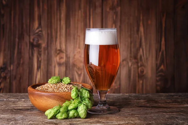 Glas av mörka öl, korn och hop kottar — Stockfoto
