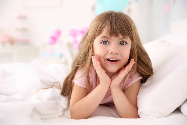 Симпатичная маленькая девочка, лежащая в кровати — стоковое фото