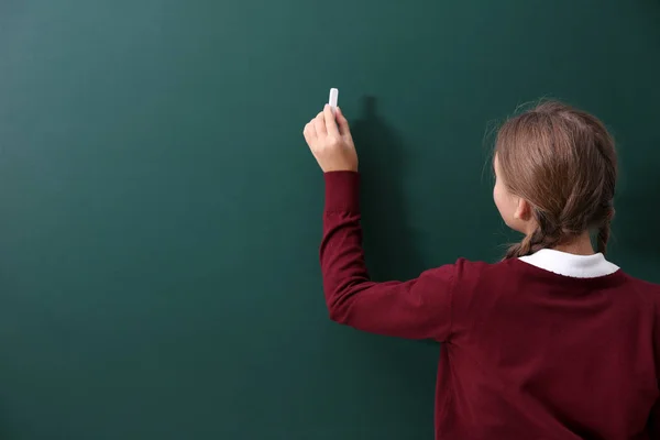 Girl near green school blackboard — Stock Photo, Image