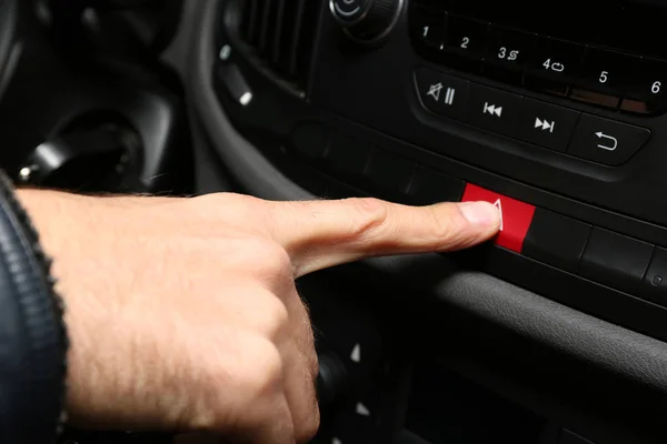 Main appuyant sur le bouton d'avertissement d'urgence sur la voiture — Photo