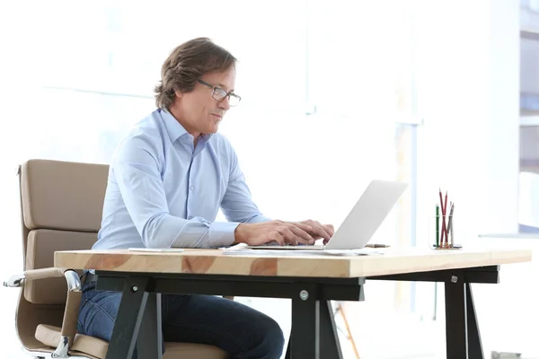 Mature man working with laptop