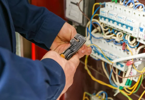 Eletricista descascando extremidades de fios — Fotografia de Stock