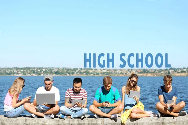 若い人たちは 屋外の勉強の現代装置を使用して 背景にテキスト高校 — ストック写真