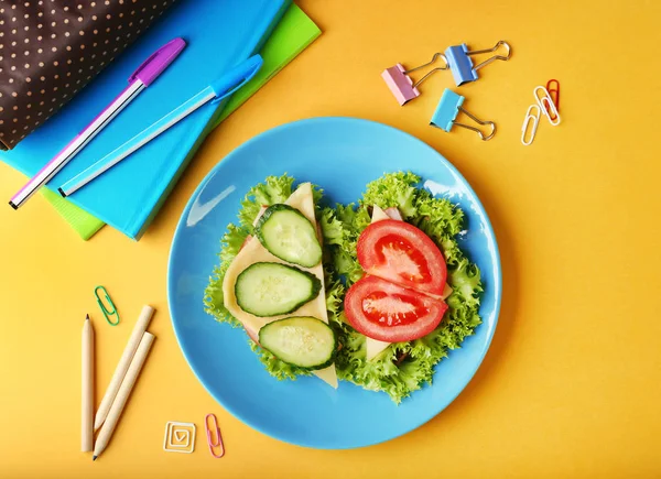 Blue plate with tasty sandwiches and stationery — Stock Photo, Image