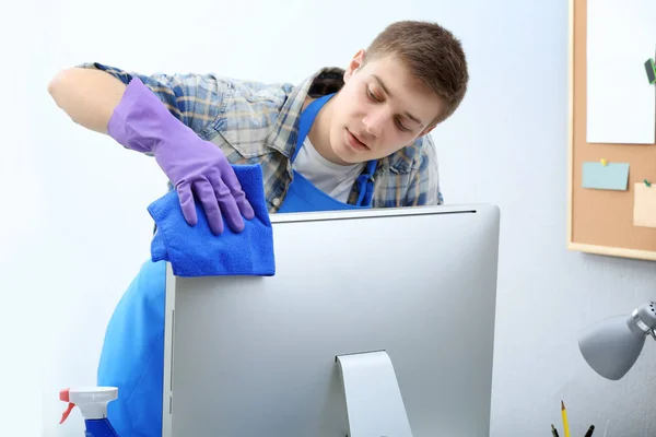 Young man cleaning computer — Stock Photo, Image