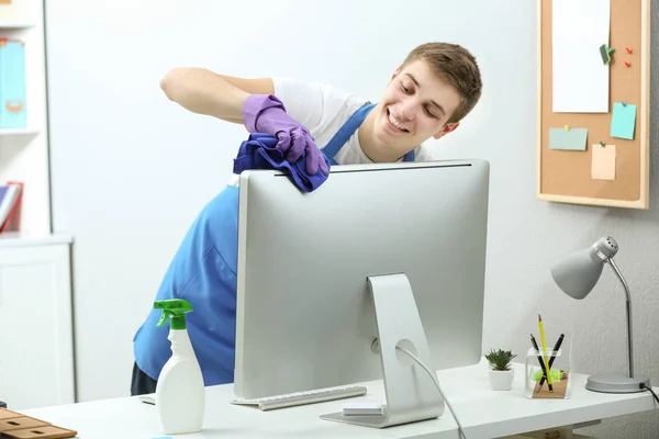 Young man cleaning computer