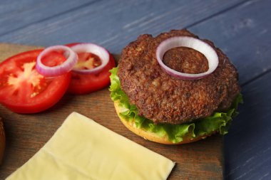 Ahşap masa üzerinde lezzetli peynirli burger