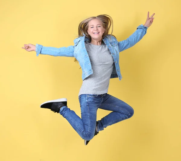 Красива дівчина-підліток стрибає на жовтому тлі — стокове фото