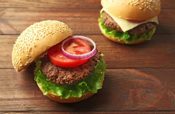 Köstlicher Cheeseburger auf Holztisch — Stockfoto