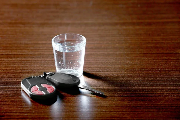 Glass of alcoholic beverage and car key — Stock Photo, Image