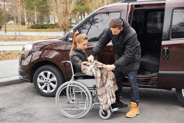 Young man helping handicapped woman
