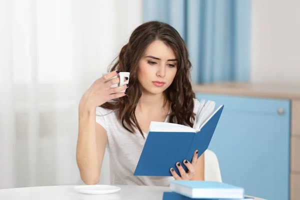 Bella giovane donna che legge libro a casa — Foto Stock