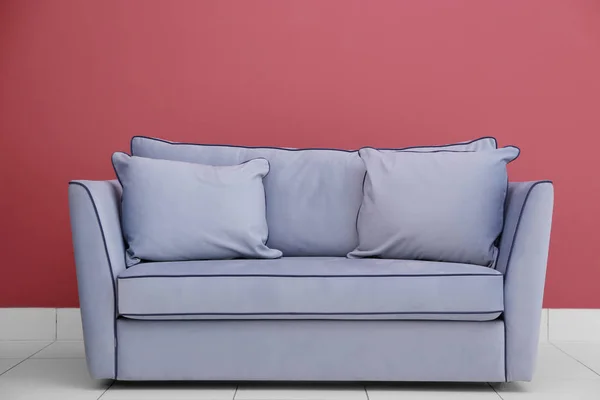 Сучасний диван на червоній стіні — стокове фото
