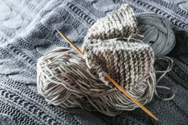 Yarn and needles on knitted scarf — Stock Photo, Image