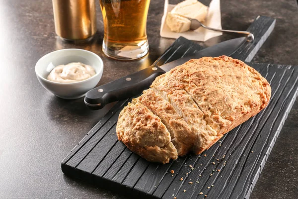Board with tasty loaf of beer bread — Stock Photo, Image