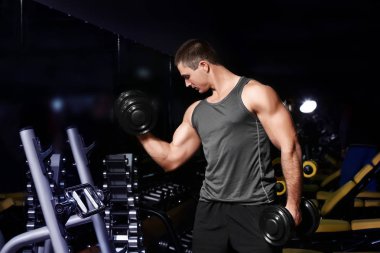 Eğitim dumbbells ile genç adam 