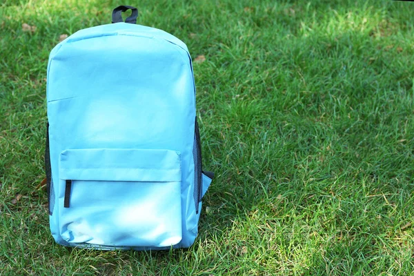 Çimenlerin üzerinde mavi sırt çantası — Stok fotoğraf