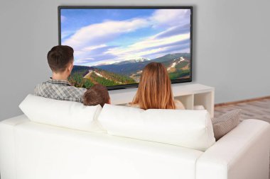 Evde televizyon izlerken aile. Boş zaman ve eğlence kavramı.