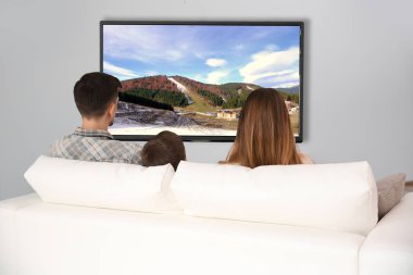 Evde televizyon izlerken aile. Boş zaman ve eğlence kavramı.