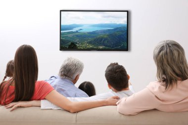 Evde televizyon izlerken aile. Boş zaman ve eğlence kavramı.