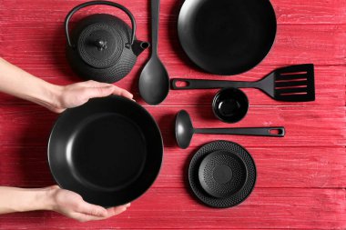 Eller ve dishware kırmızı ahşap zemin üzerinde