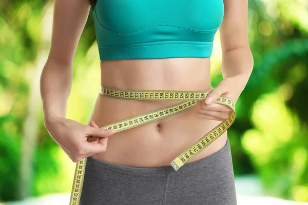 Young woman with measuring tape — Stock Photo, Image