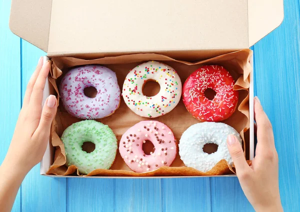 Caja de mano femenina con rosquillas —  Fotos de Stock