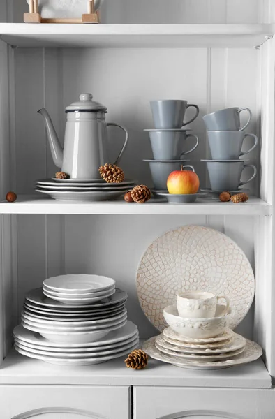 Different clean dishes in cupboard