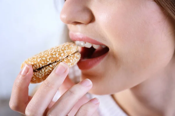 Jeune femme manger un cookie — Photo