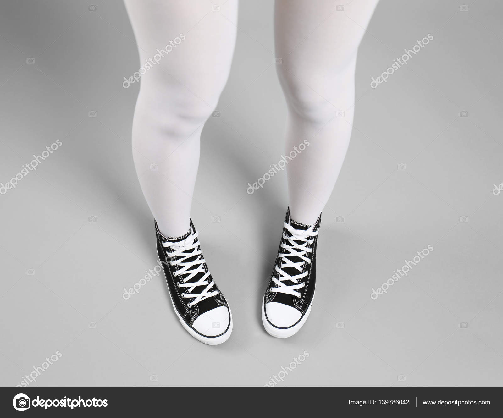 Woman in white tights and sneakers Stock Photo by ©belchonock