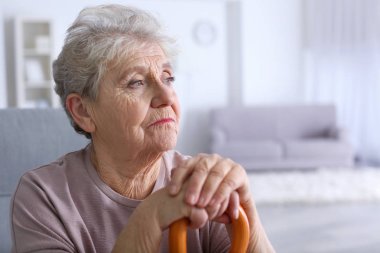 Yaşlı kadın evde baston ile