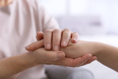Hands of elderly mother and daughter clipart